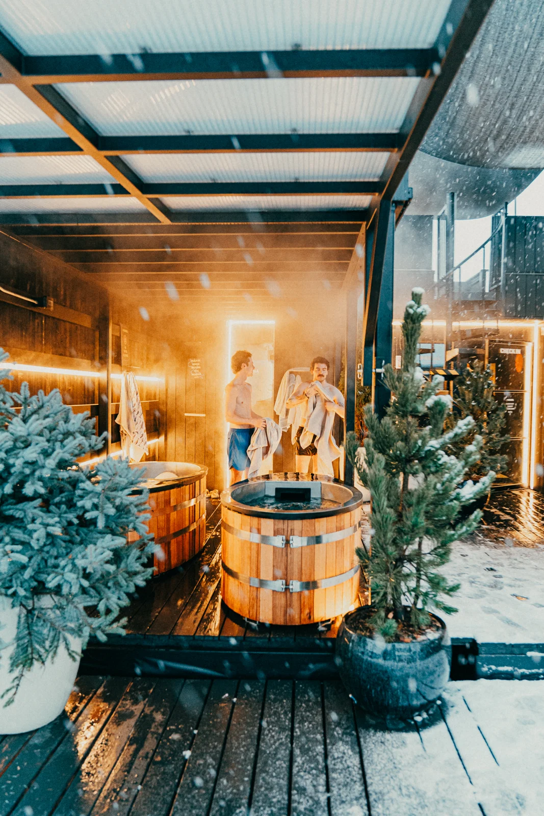 Guests in robes beside wooden plunge tubs at PORTAL° Bozeman