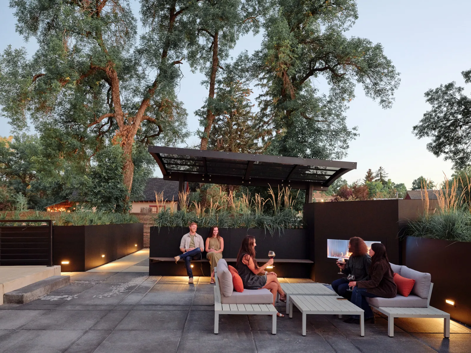 Friends gathering beside the outdoor fireplace at Vintage Estate